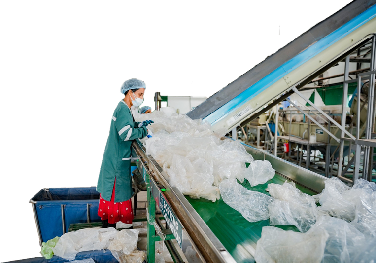 Green Worms worker sorting plastic on a conveyor